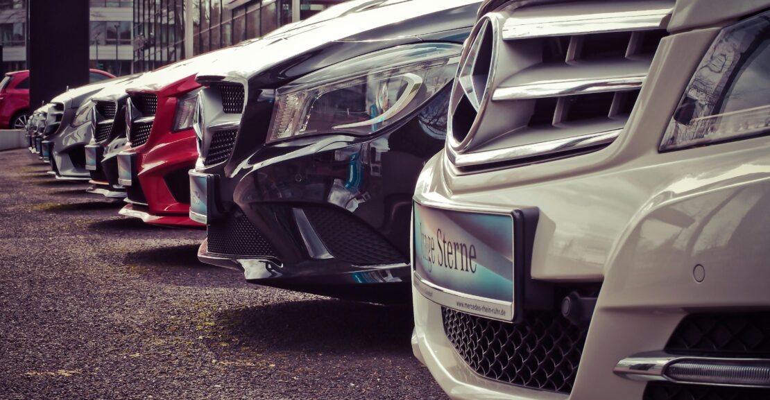 Luxury cars lined up at an outdoor dealership, showcasing sleek designs.