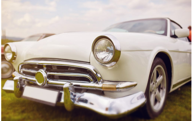 Retro car parked on grass. Film effect filter