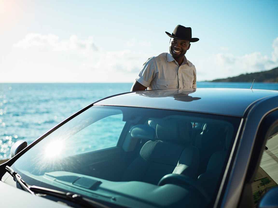 Happy customer standing beside Dove Auto Solutions rental car in St Mark Grenada showing trusted service